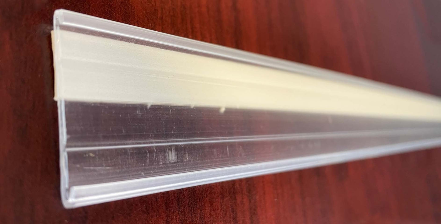 Vestcom 1-1/4" x 4' Clear Shelf Molding, priced per four-foot strip, perfect for enhancing retail displays with a clean, professional look.